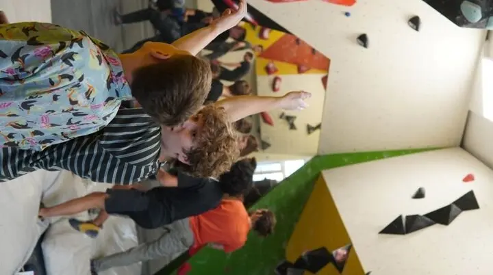 Jugendliche in einer Boulderhalle besprechen eine Kletterroute an der Wand. | © Marcel Dippon